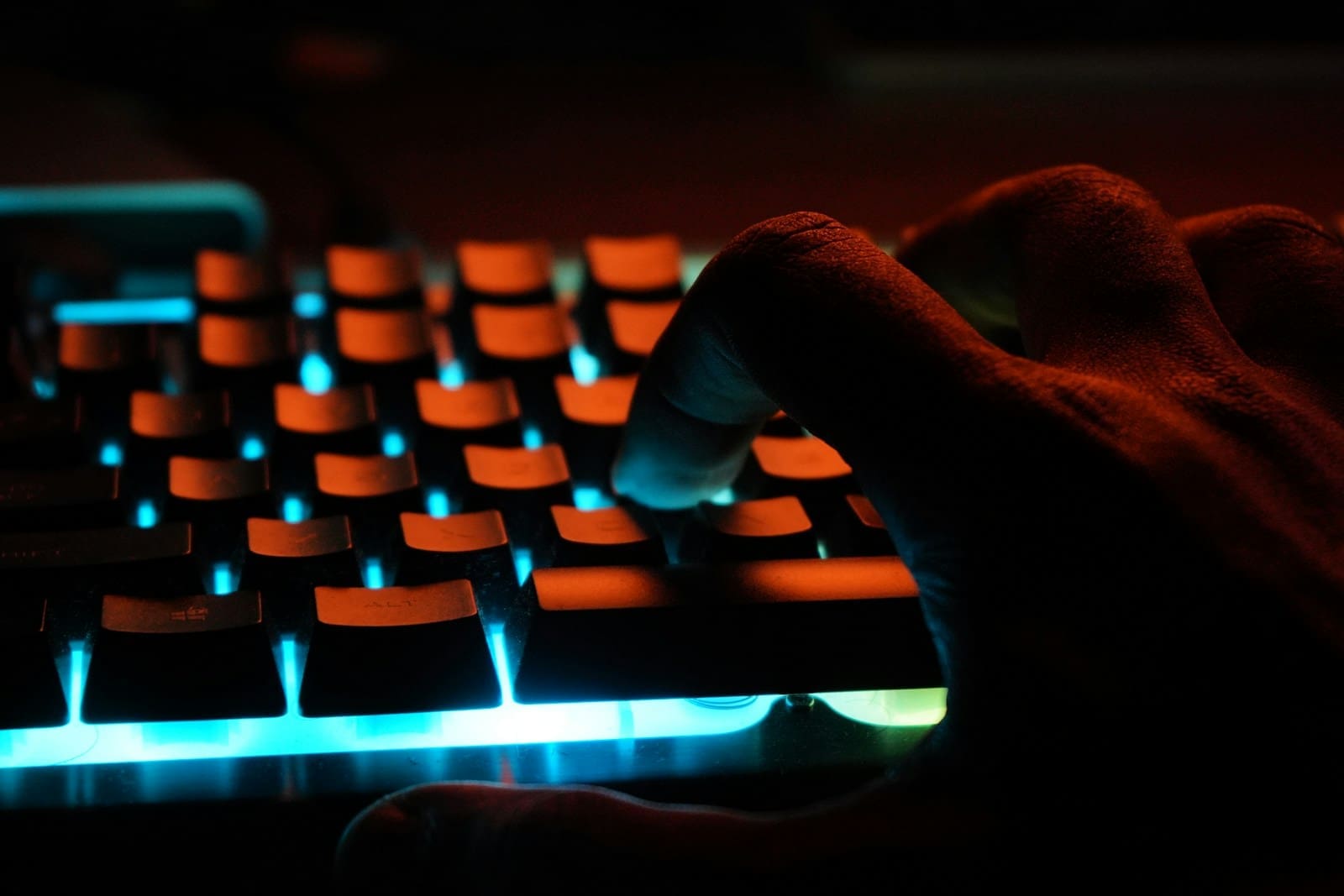 Photo by Ayrus Hill persons hand on blue lighted computer keyboard
